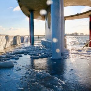 Der Brückenkopf der kellenhusener Seebrücke im Winter, das Geländer ist gefroren und der Boden ist voll Eis und Schnee