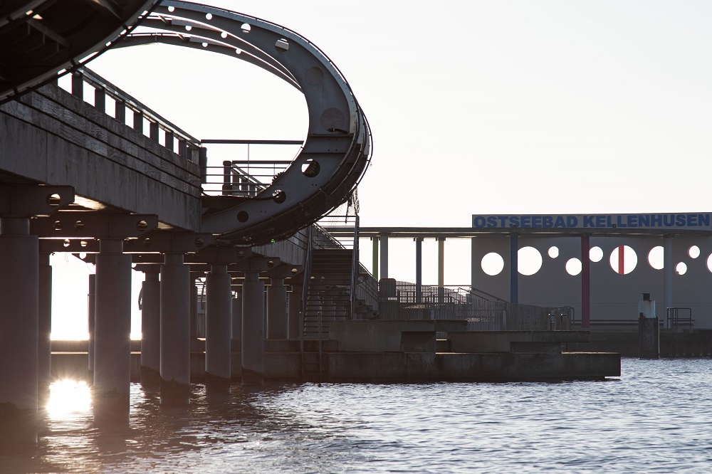 Eine Nahaufnahme der Seebrücke in Kellenhusen, im Hintergrund sieht man den Schriftzug "Ostseebad Kellenhusen"